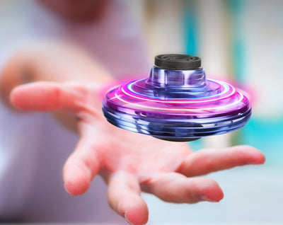 Homeshinex interactive decompression toy for kids spinning above an outstretched hand with colorful lights