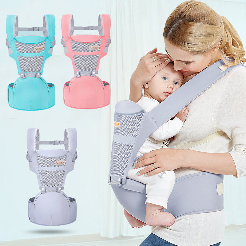 Ergonomic child sitting carrier bag in gray worn by woman holding baby with additional blue and pink carriers