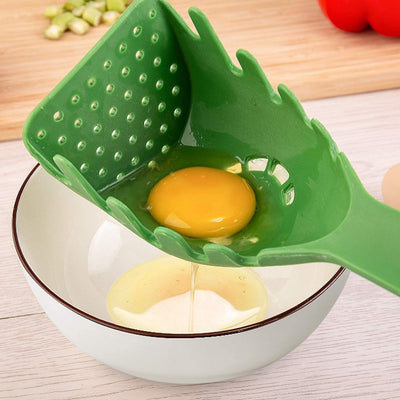Homeshinex versatile kitchen spoon for pasta and eggs in green holding an egg over a white bowl
